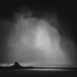 Driving across to Holy Island, Northumberland in the pouring rain, I stopped the car on the causeway just to watch, as the rain seemed backlit, the wind kept catching it and making it drift and swirl, so I just started photographing the patterns and shapes in the rain. I was totally soaked after a short time but exhilarated. I love the way the rainfall mirrors the shape of the castle.