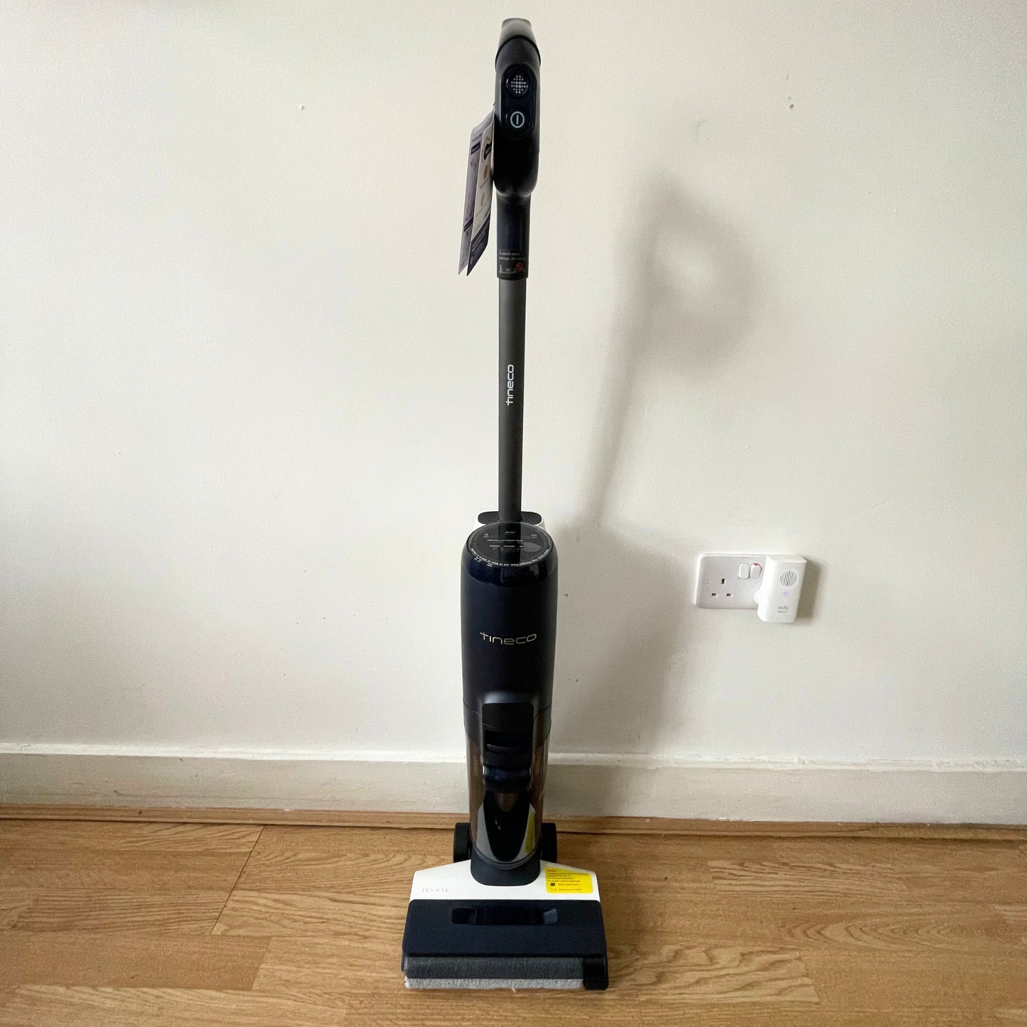Tineco Smart Mop standing up against a white wall