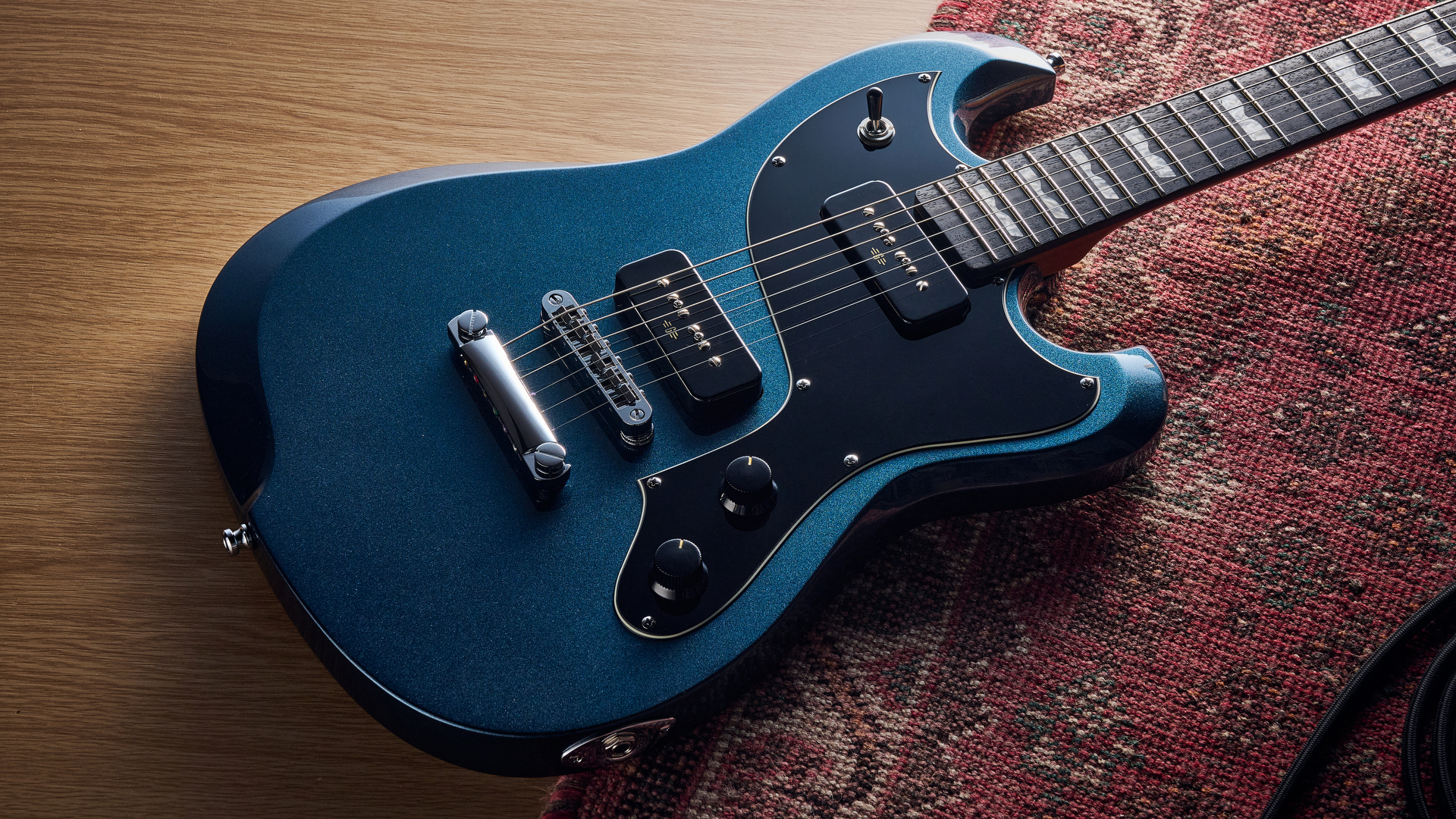 A Baum Carve electric guitar lying on a rug