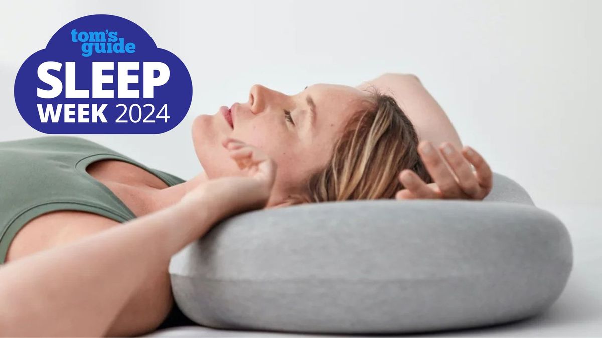 A woman laying on her back on a light gray Ostrichpillow