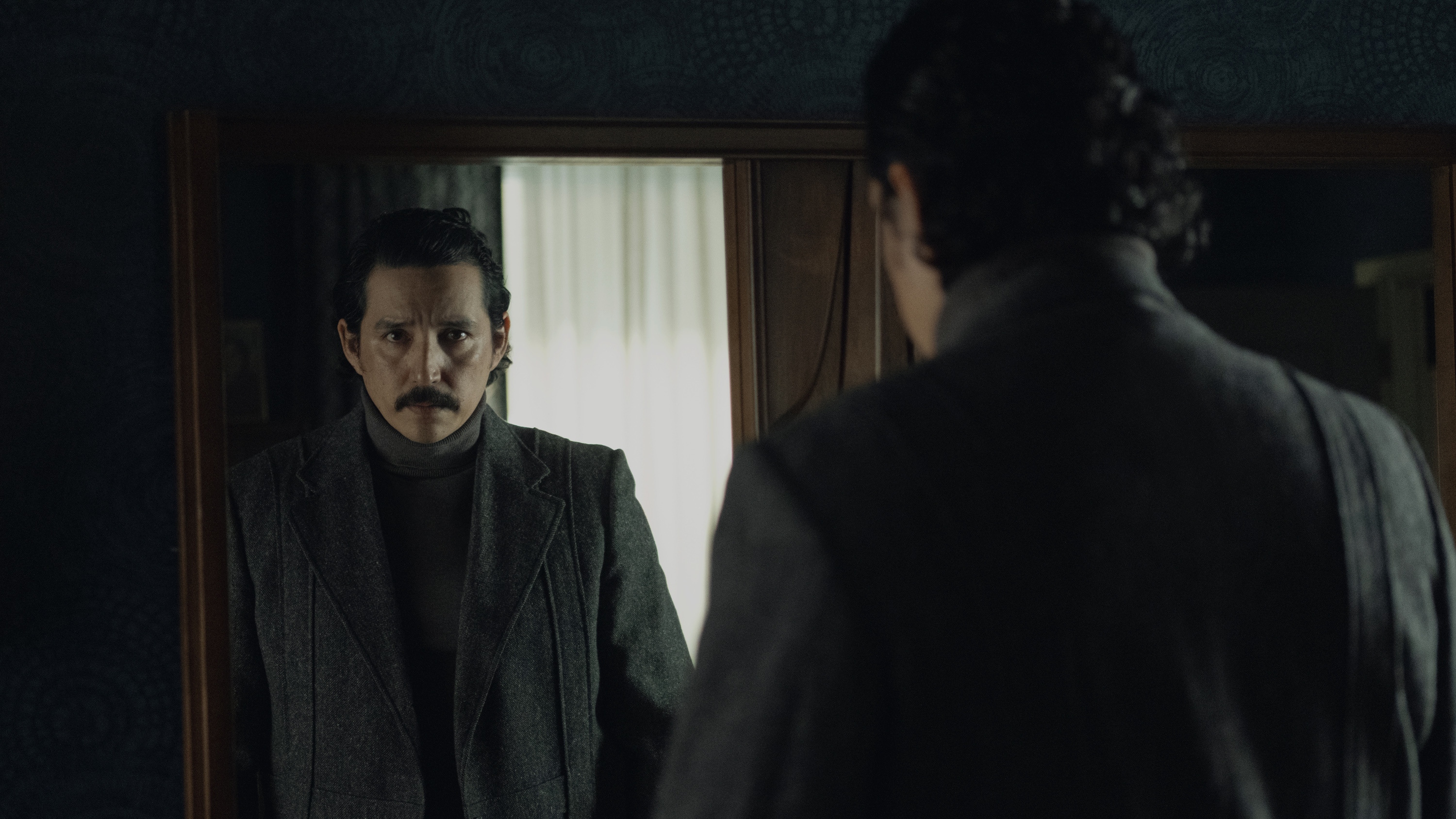 Gabriel Luna as Tovar looking at his reflection in the mirror.