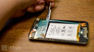 Pry up logic board with pry tool on iPod touch