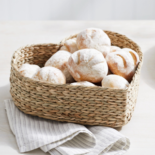 A heart-shaped bread basket filled with rolls