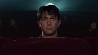 Joseph Gordon-Levitt sits alone in an empty movie theater looking miserable in 500 Days of Summer.