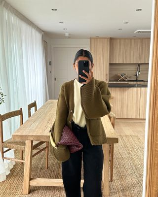 Fashion influencer Monikh Dale takes a mirror selfie in the burgundy with butter yellow color trend.