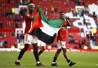 Paul Pogba (left) and Amad Diallo hold up the flag of Palestine