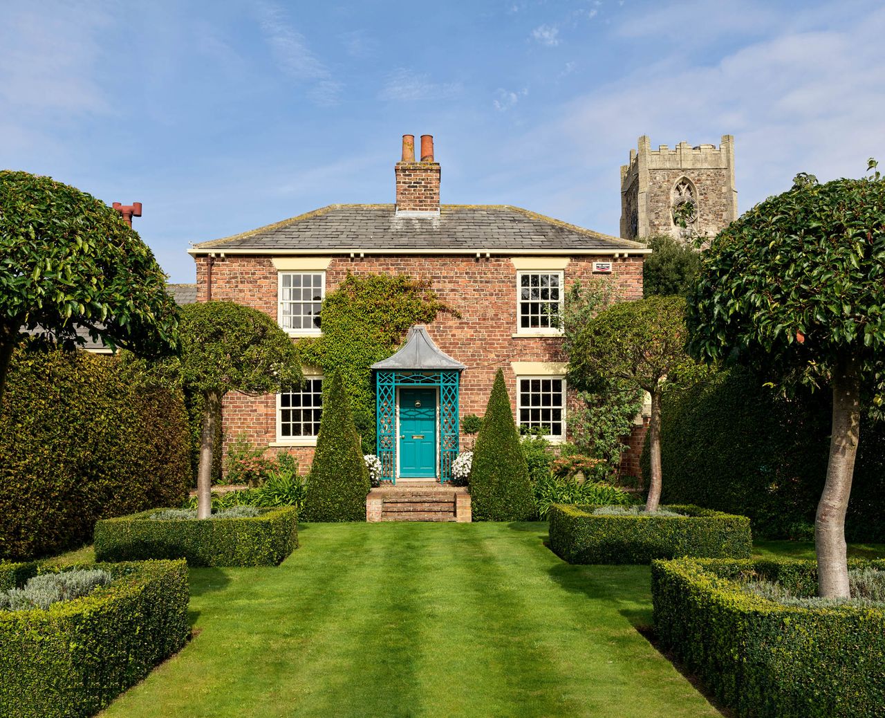 Fig 1: The cottage and its small formal garden in the shadow of the parish church. Church Cottage, Humbleton, South Yorkshire. Photographed by Paul Highnam for Country Life. ©Country Life