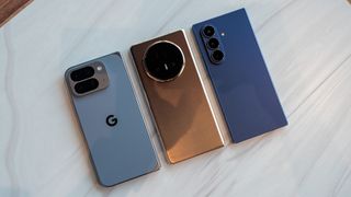 Comparing the size and thickness of the Google Pixel 10 Pro Fold (light blue), Honor Magic V5 (gold/copper), and Samsung Galaxy Z Fold 7 (dark blue)