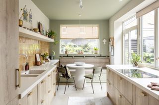 A galley kitchen with banquette seating by the window