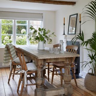 Neutral country dining room with wooden floor, white walls and farmhouse table