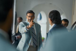 Ajay Devgn wears a suit and points at a man in maidaan