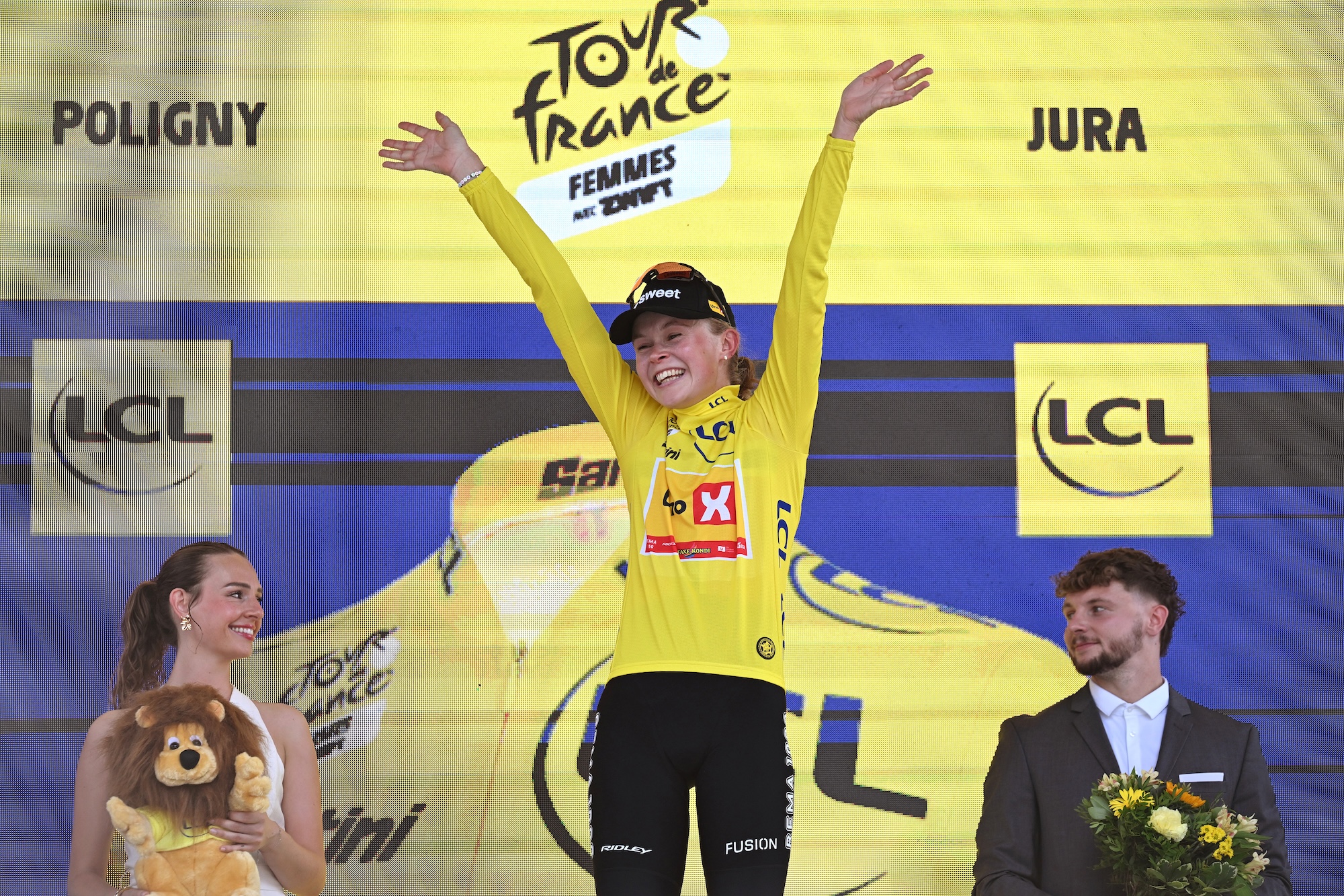 Sigrid Haugset of Uno-X Mobility celebrates on the podium in the yellow jersey after stage 3 of the Tour de France Femmes