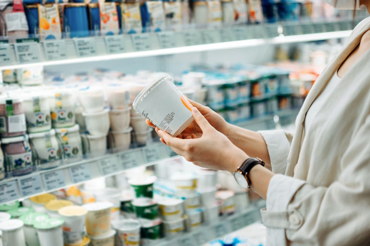 Woman looking at yogurt in supermarket