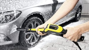 Karcher pressure washer being used to clean a silver car