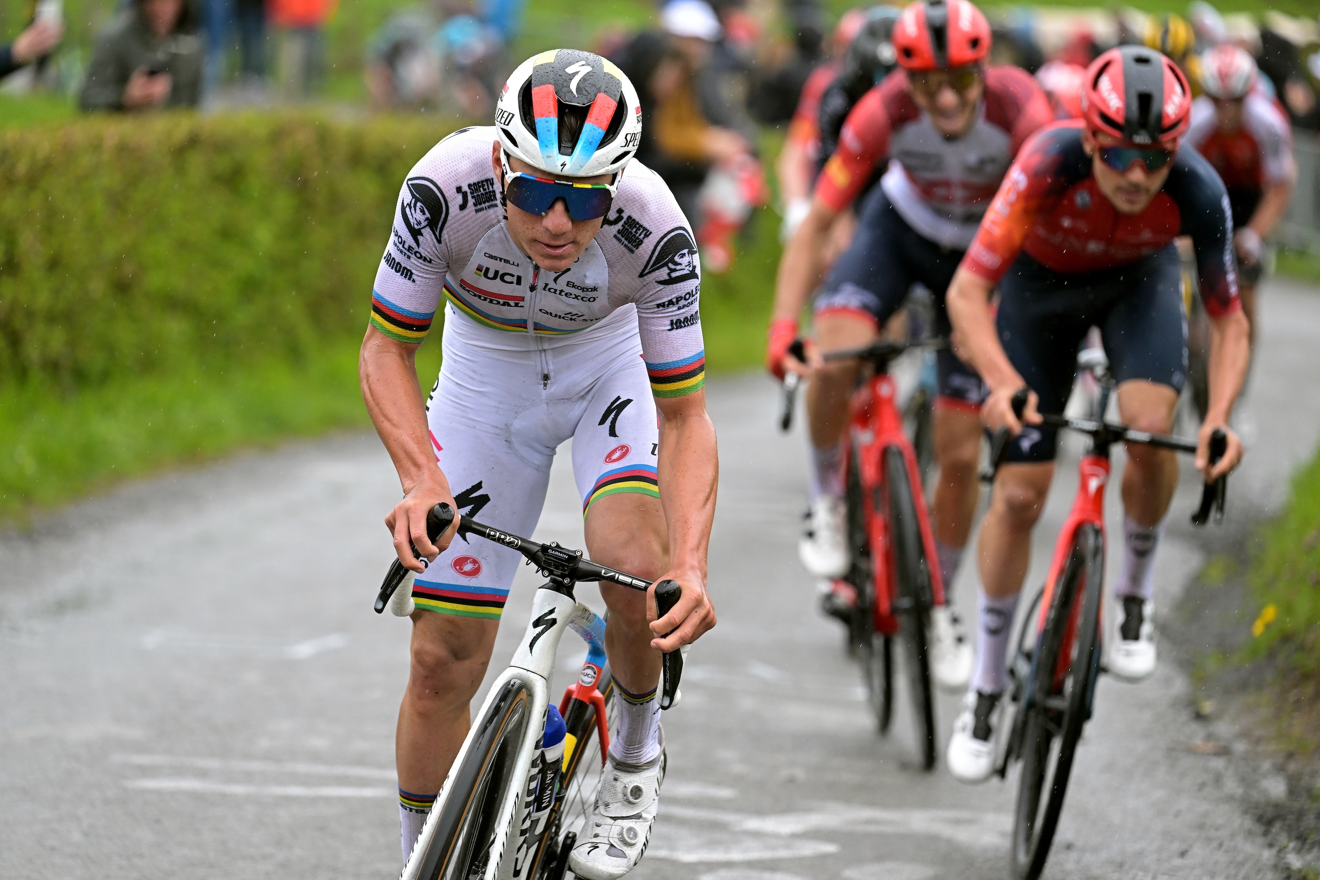 Remco Evenepoel racing in white kit with rainbow bands