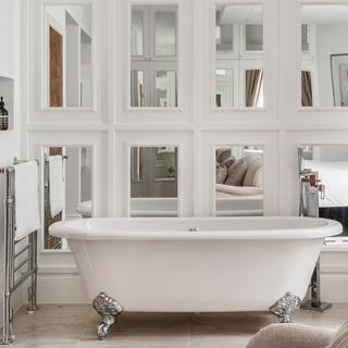 bathroom with bathtub white mirrored wall