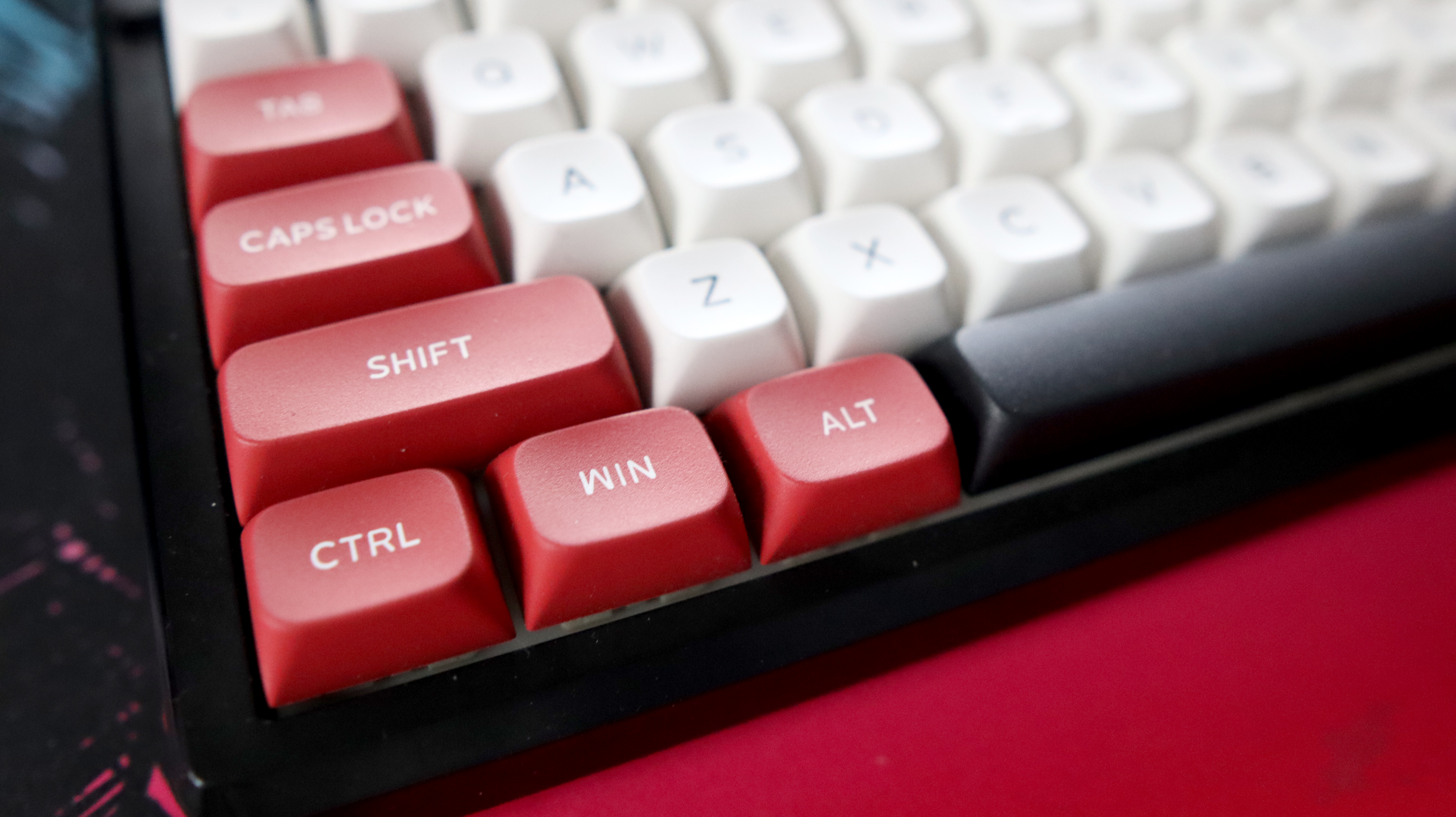 The Gamakay TK101 gaming keyboard in a red and white colourway and on a colourful mouse pad.