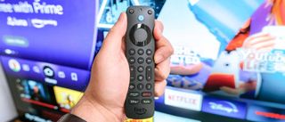 The Alexa Voice Remote Pro in hand in front of a TV