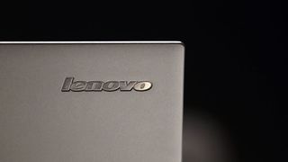 The Lenovo logo on a laptop, against a black background