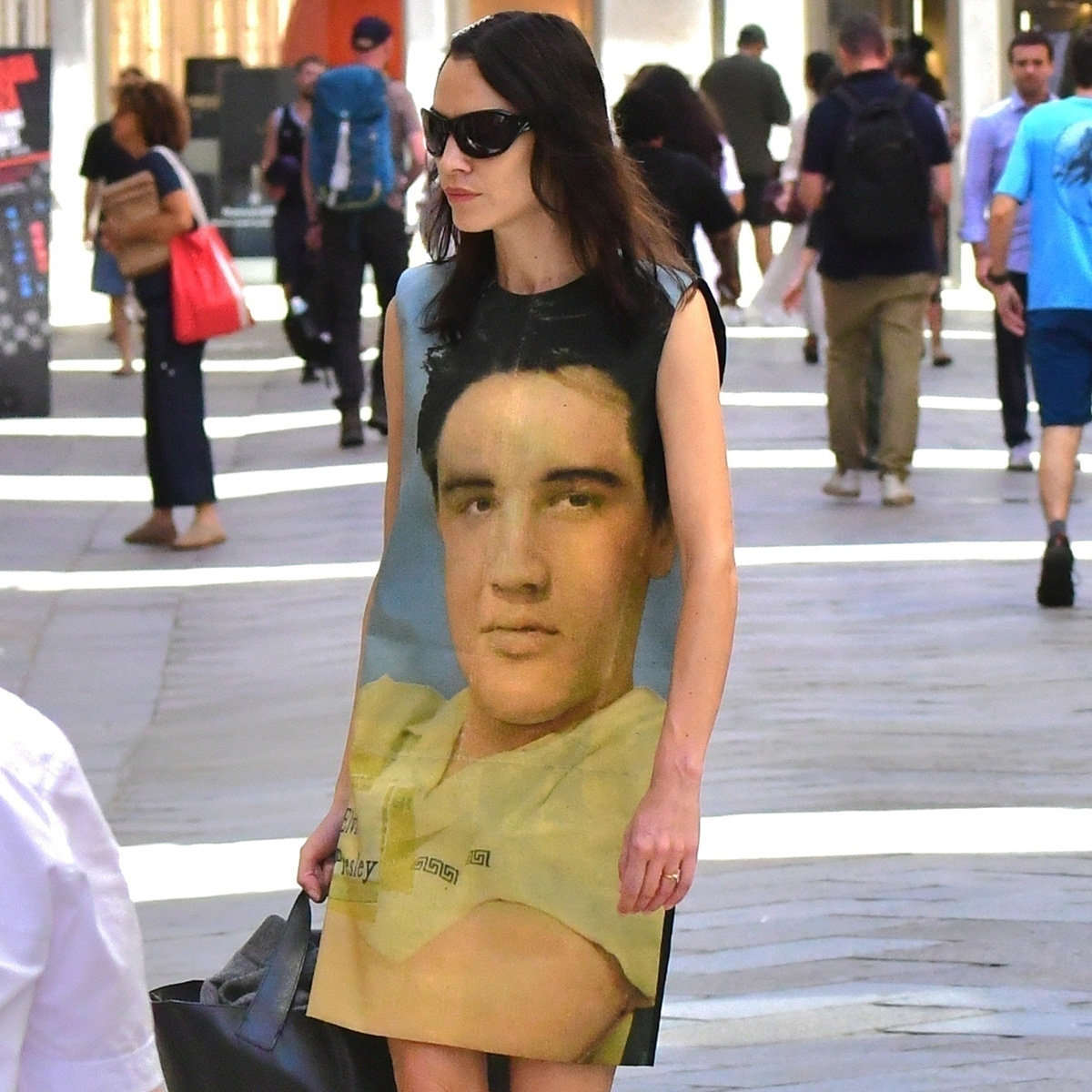 Alexa Chung wears an elvis graphic mini dress and black sunglasses.