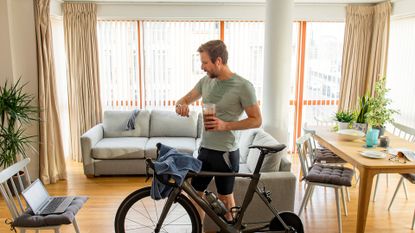 Image shows a cyclist have a protein recovery drink after cycling.