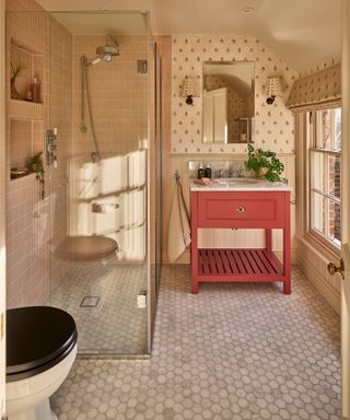 small cottage bathroom with shower cubicle, tiled floor and walls, pink vanity unit with inset sink