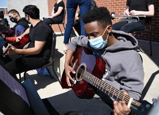 A John Overton High School student in Nashville plays an Epiphone acoustic guitar donated by Gibson