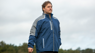 A golfer poses in the ProQuip StormForce PX8 Rain Jacket