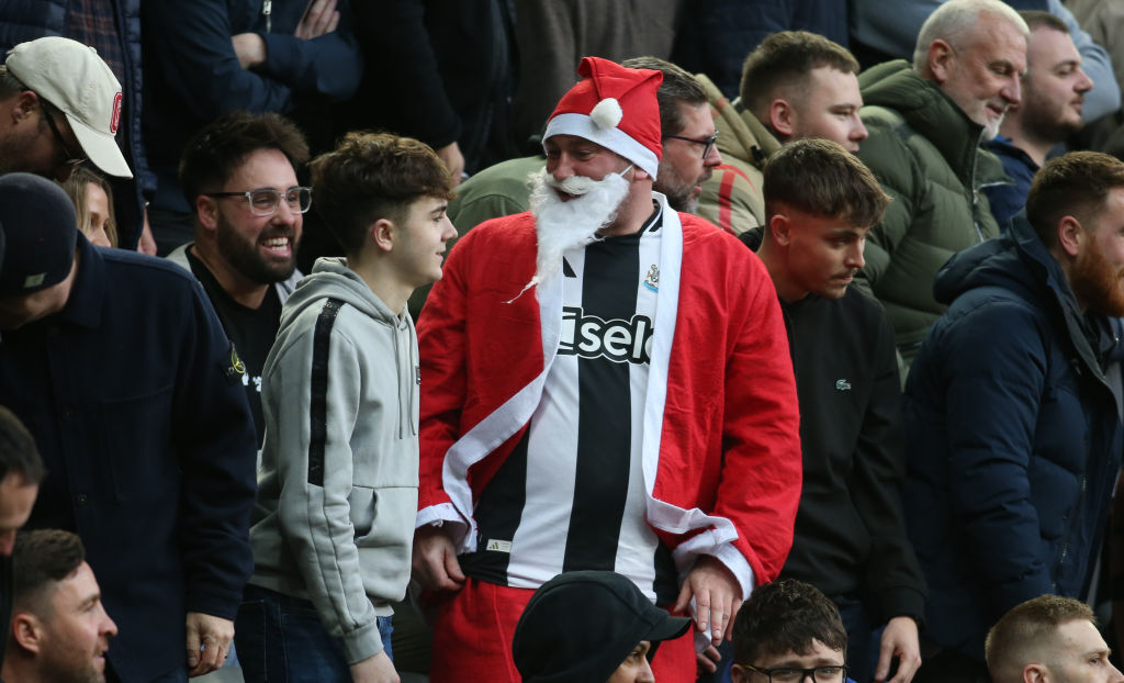 A Newcastle United fan wearing a Father Christmas outfit in the stands