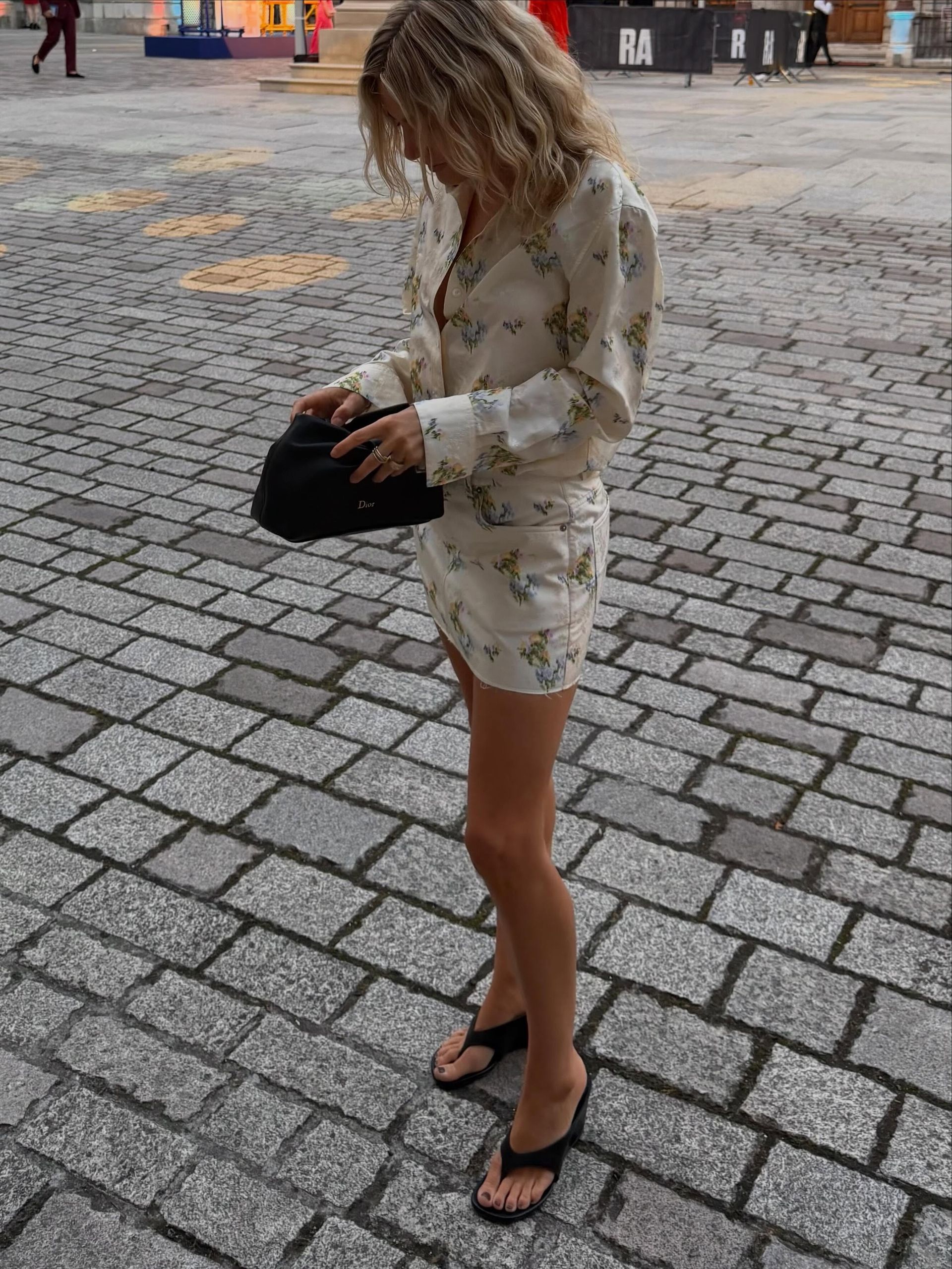 Influencer @lucywilliams02 wears a floral minidress with sculptural wedge thong heels.
