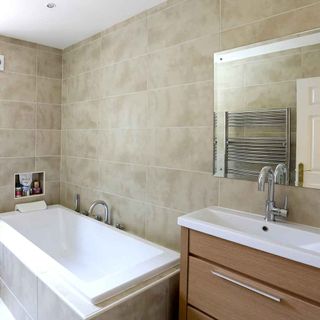 bathroom with wall tiles and wash basin with bathtub