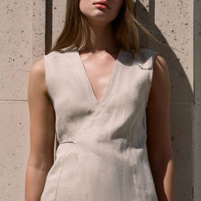 A model wearing a beige, linen tunic from Faithfull.