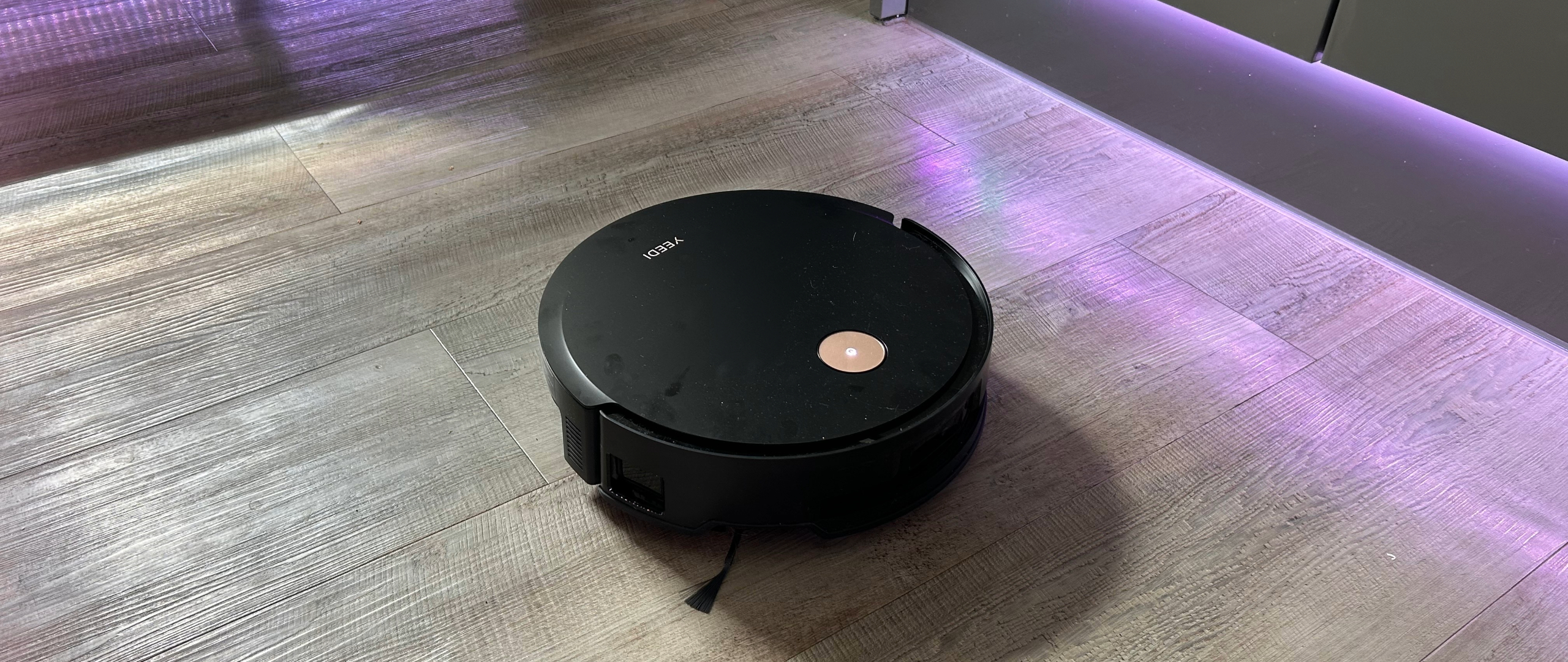 YEEDI S14 Plus Robot Vacuum and Mop on Megan&#039;s wooden vinyl kitchen floor with LED lights on cabinets in the background