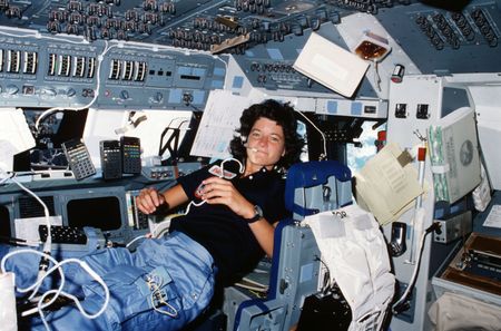 Floating freely on the flight deck, Sally Ride communicates with ground controllers in Houston during her STS-7 mission in June 1983.