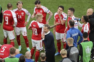 Denmark head coach Kasper Hjulmand talks to his squad on the pitch