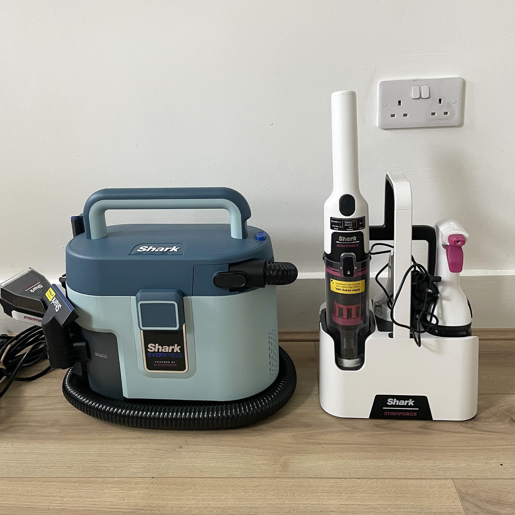 Shark EveryMess and Shark StainForce sitting next to each other on wood effect flooring