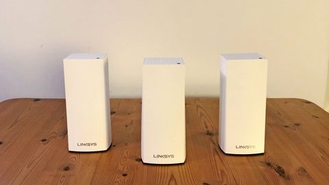 Linksys Atlas Pro 6 routers on a wooden table