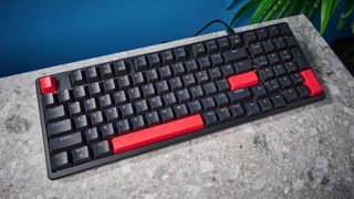 A black Lemokey X5 wired mechanical keyboard with red and black keycaps