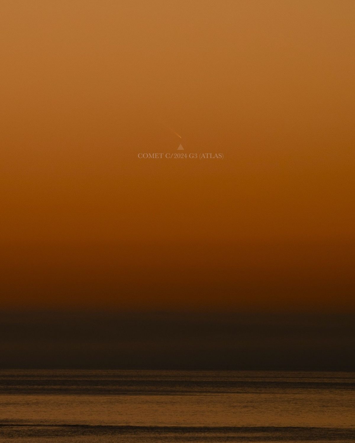 comet above water shining against a deep orange sky.