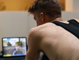 A sweating rider training on a smart trainer using Zwift