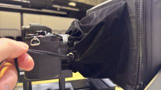 Neewer Teleprompter X14 III hood drawstrings being closed around a camera lens