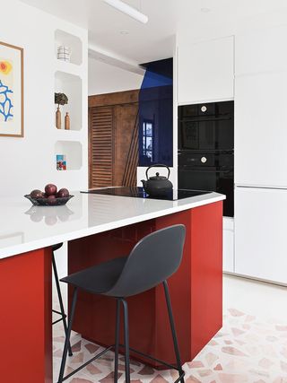A red kitchen island in an all-white kitchen