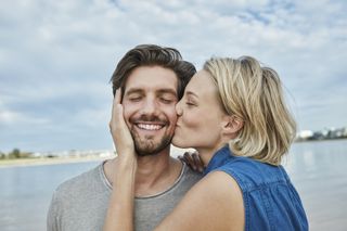 HPV symptoms in women: Happy young couple kissing on the beach