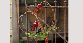willow heart-shaped wreath hanging on an outside gate to suggest an easy Valentine's day decoration for exteriors