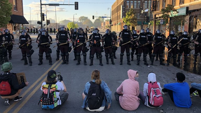 topshot people sit on the street in front of a row of police officers during a rally in minneapolis, minnesota, on may 29, 2020 after the death of george floyd, a black man who died after a white policeman kneeled on his neck for several minutes demonstrations are being held across the us after george floyd died in police custody on may 25 photo by kerem yucel afp photo by kerem yucelafp via getty images