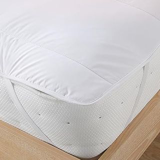 The corner of the Slumberland Wonderful Wool Mattress Topper secured to a mattress with an elasticated strap