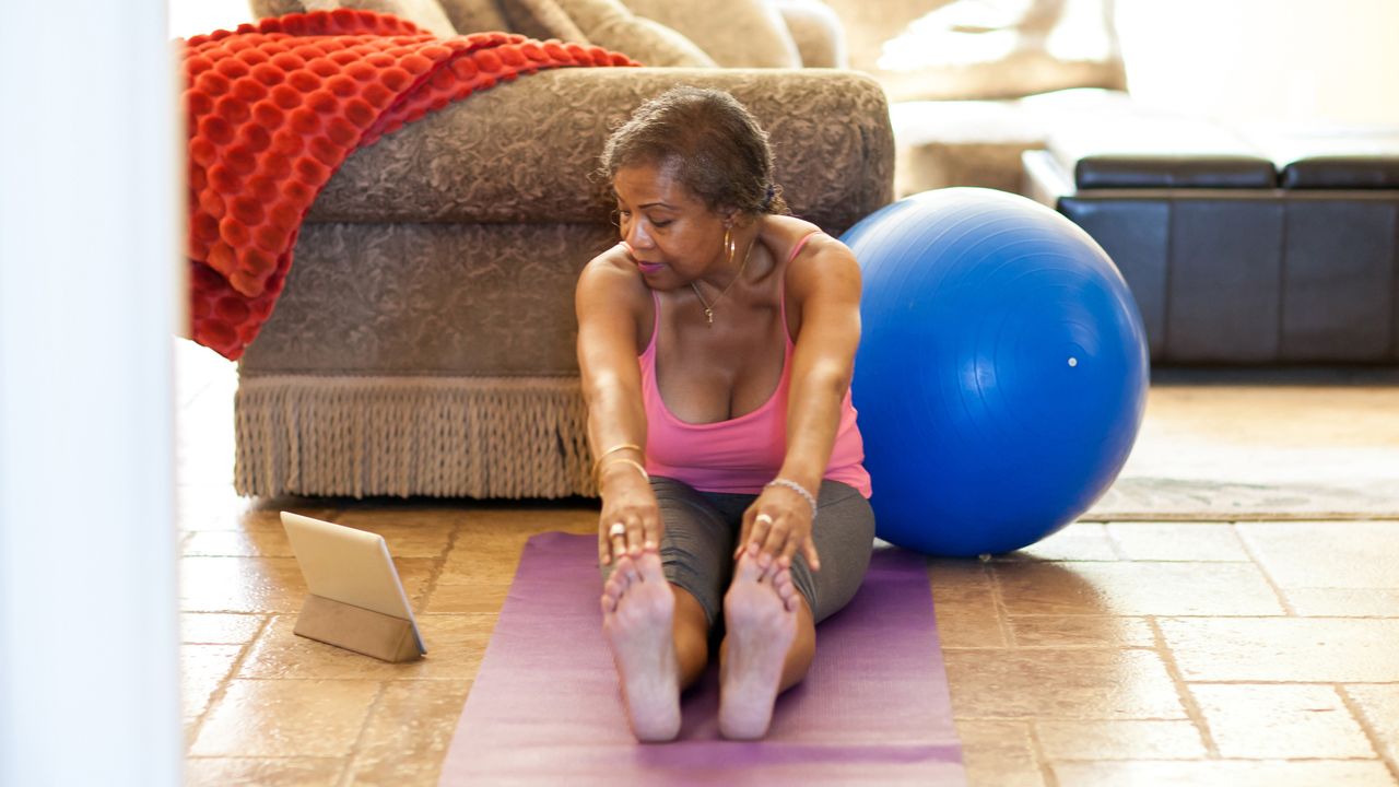 older woman touching her toes and stretching