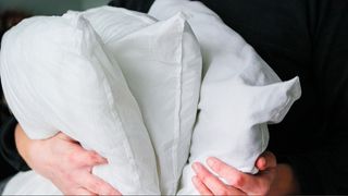 three white pillows in person's hands