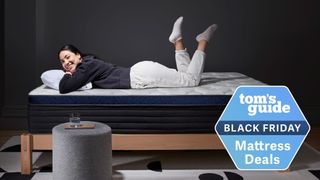 A woman laying on a Helix mattress on a wooden bedframe in a grey bedroom