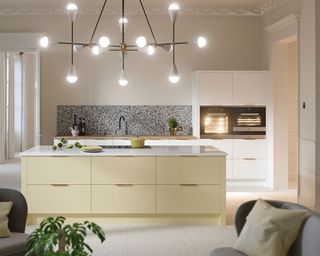 Yellow kitchen island and white units by Wren Kitchens